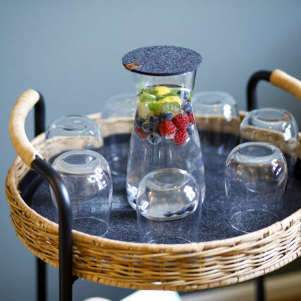 Wasser mit Obst in Karaffe und Glässern auf einem Beistelltisch